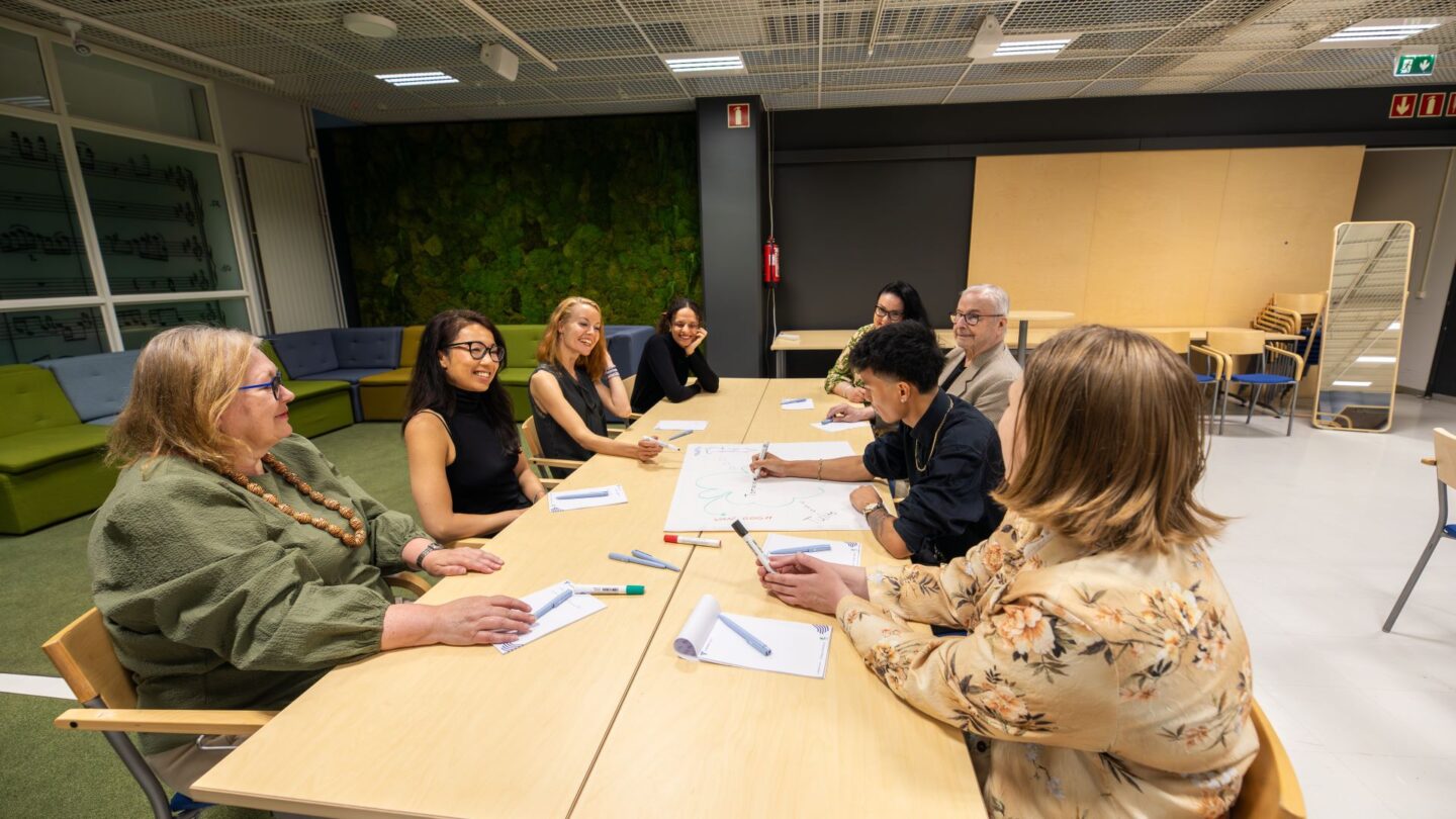 Ihmisiä kokoustamassa Sonaatti 1 kokoustilassa Tampere-talossa. People having a meeting in the Sonaatti 1 meeting room at Tampere Hall.