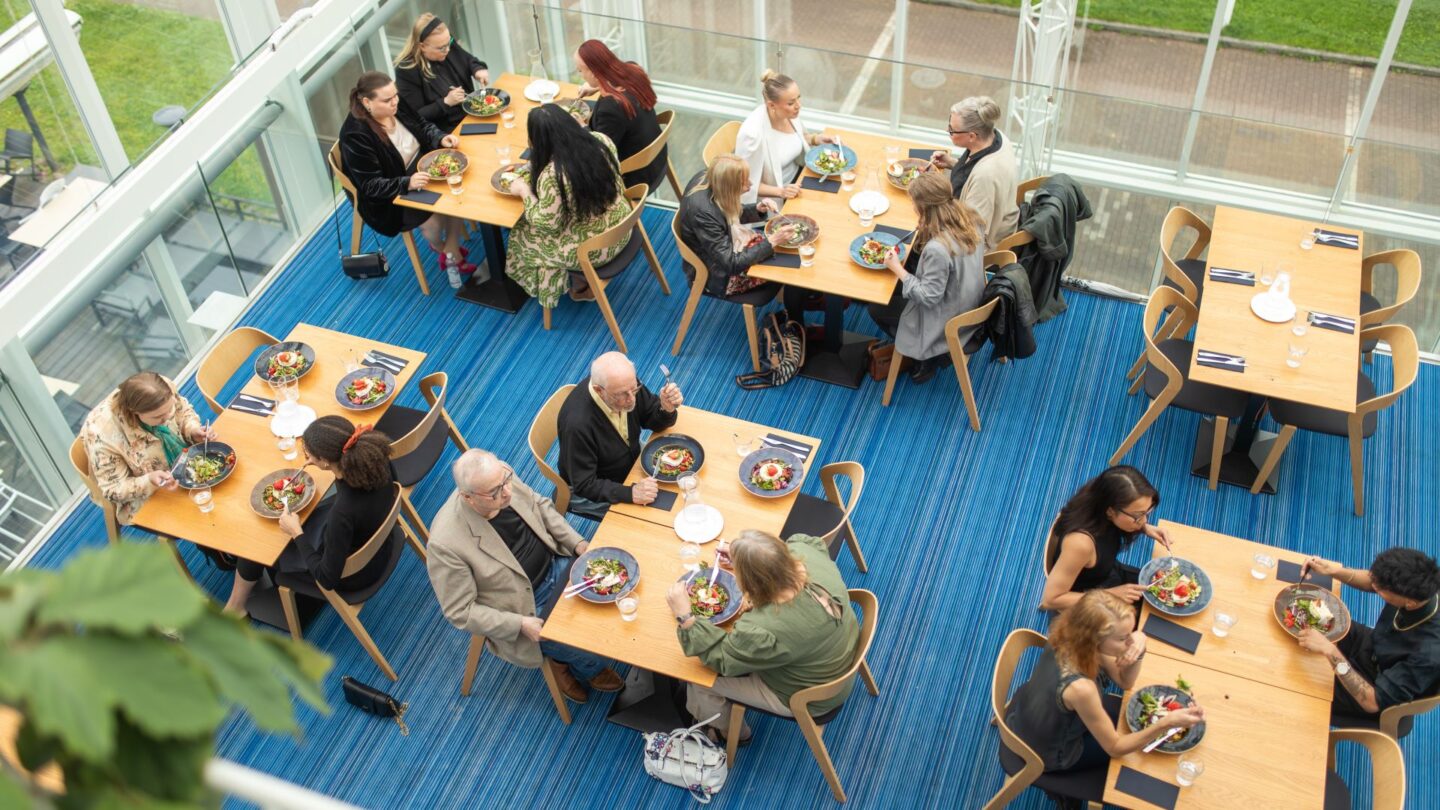 Ihmisiä bisneslounaalla Majakka-tilassa Tampere-talossa. People having a business lunch in the Majakka room at Tampere Hall.