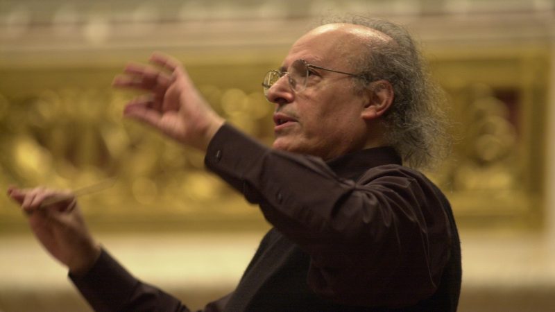 Tampere Filharmonian Yön Laulu konsertissa vieraileva kapellimestari Eliahu Inbal seisoo ja ohjaa orkesteria