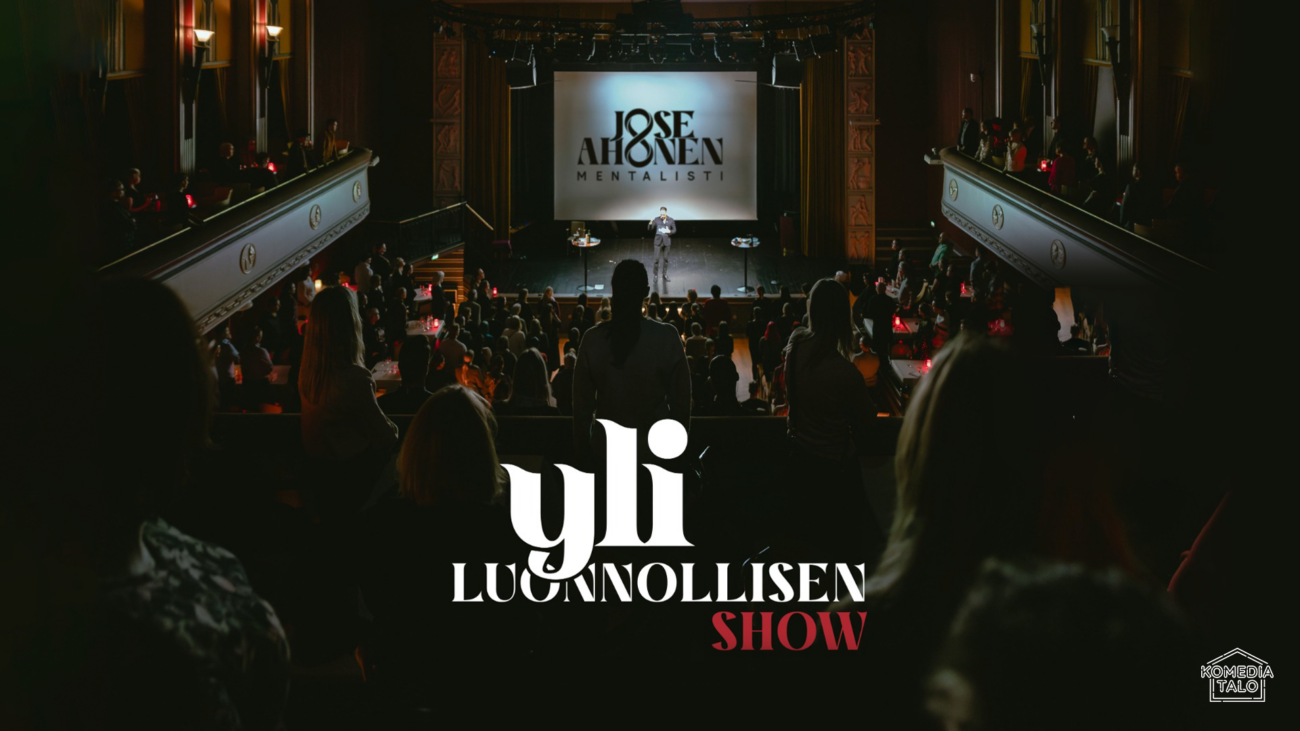 Tumma näkymä teatterista, jossa yleisö katsoo lavalle.