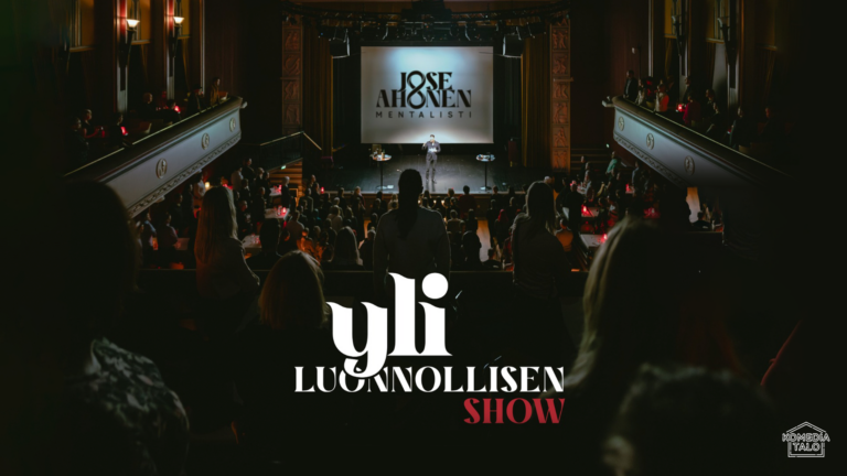 Tumma näkymä teatterista, jossa yleisö katsoo lavalle.