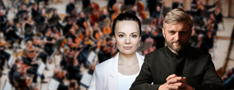 Kapellimestari ja sopraano etualalla ja taustalla näkyy orkesteri sumeana.