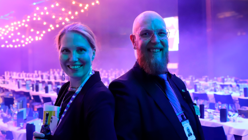 Tampere-talon henkilökuntaa ja turvallisuus henkilökuntaa lähikuvassa juhlavassa tilassa hymyillen