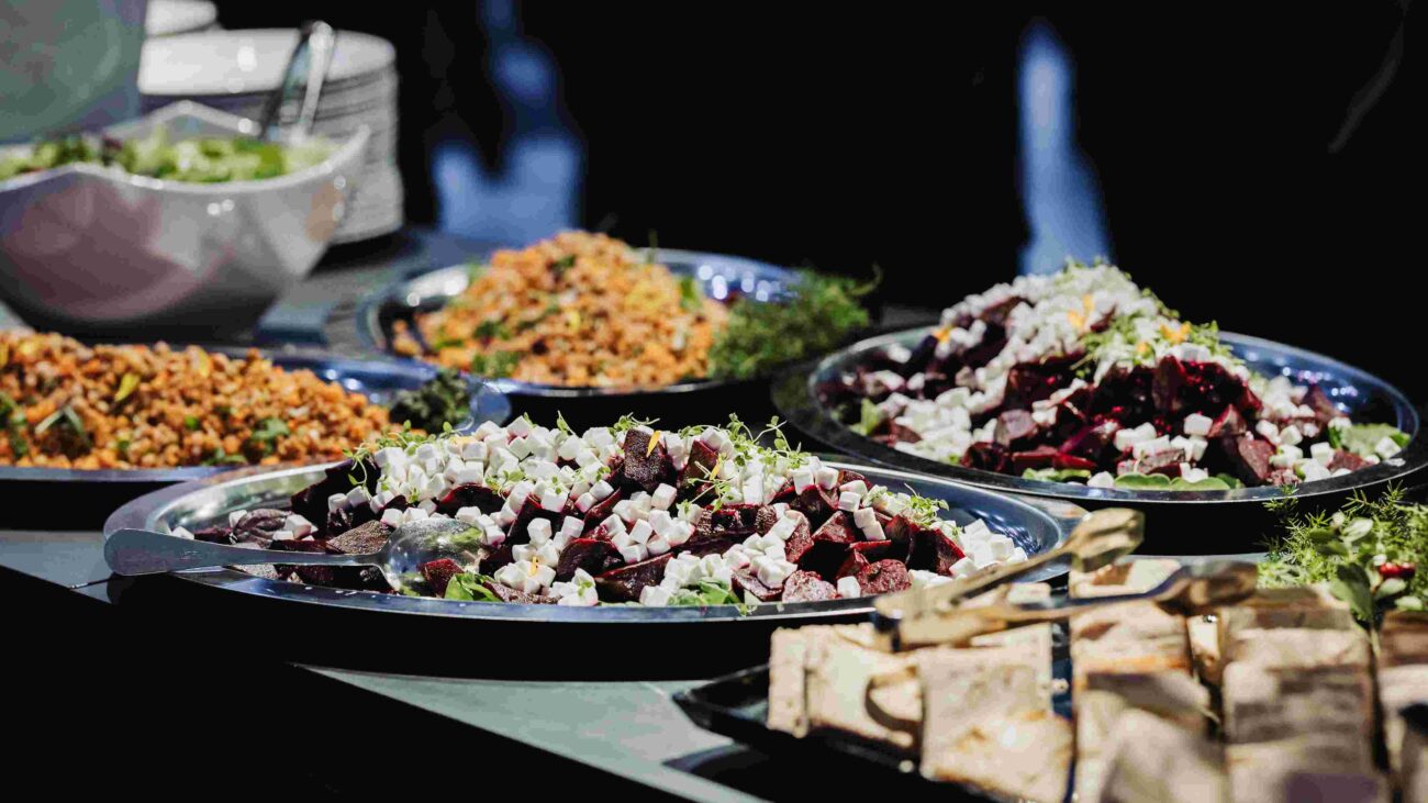 Buffet-tyylinen ruokapöytä, jossa erilaisia salaatteja.