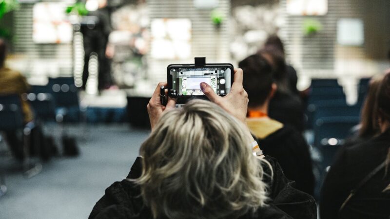 Seminaari osaLLISTUJA KUVAA PUHEENVUOROA PUHELIMELLAAN