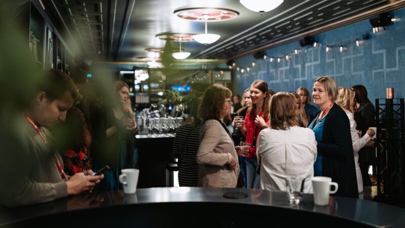 Guests chatting informally in the Tuulensuu Palace bar area during a break at Monetra’s staff day.