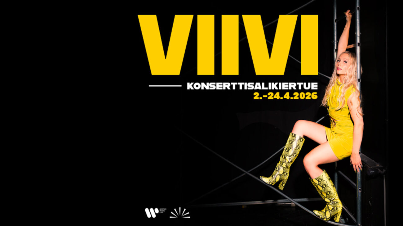 Artisti VIIVI poseeraa viettelevästi keltaisessa vaatteessa ja bootseissa.