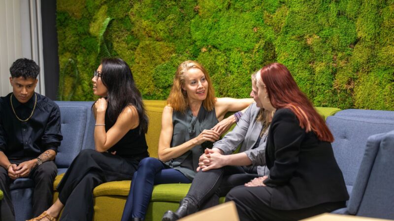 Ihmisiä juttelemassa rennosti kokouksen yhteydessä sohvalla