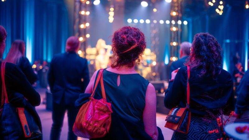 Nainen kulkemassa kohti juhlavaoin valaistua lavaa