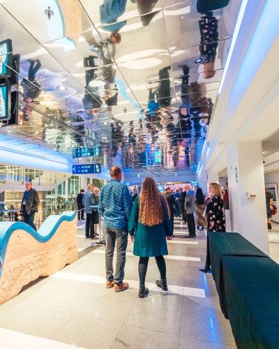 Talo Evenstin tapahtumapalveluiden kävijät Tampere-talon valoisella pääkäytävällä
